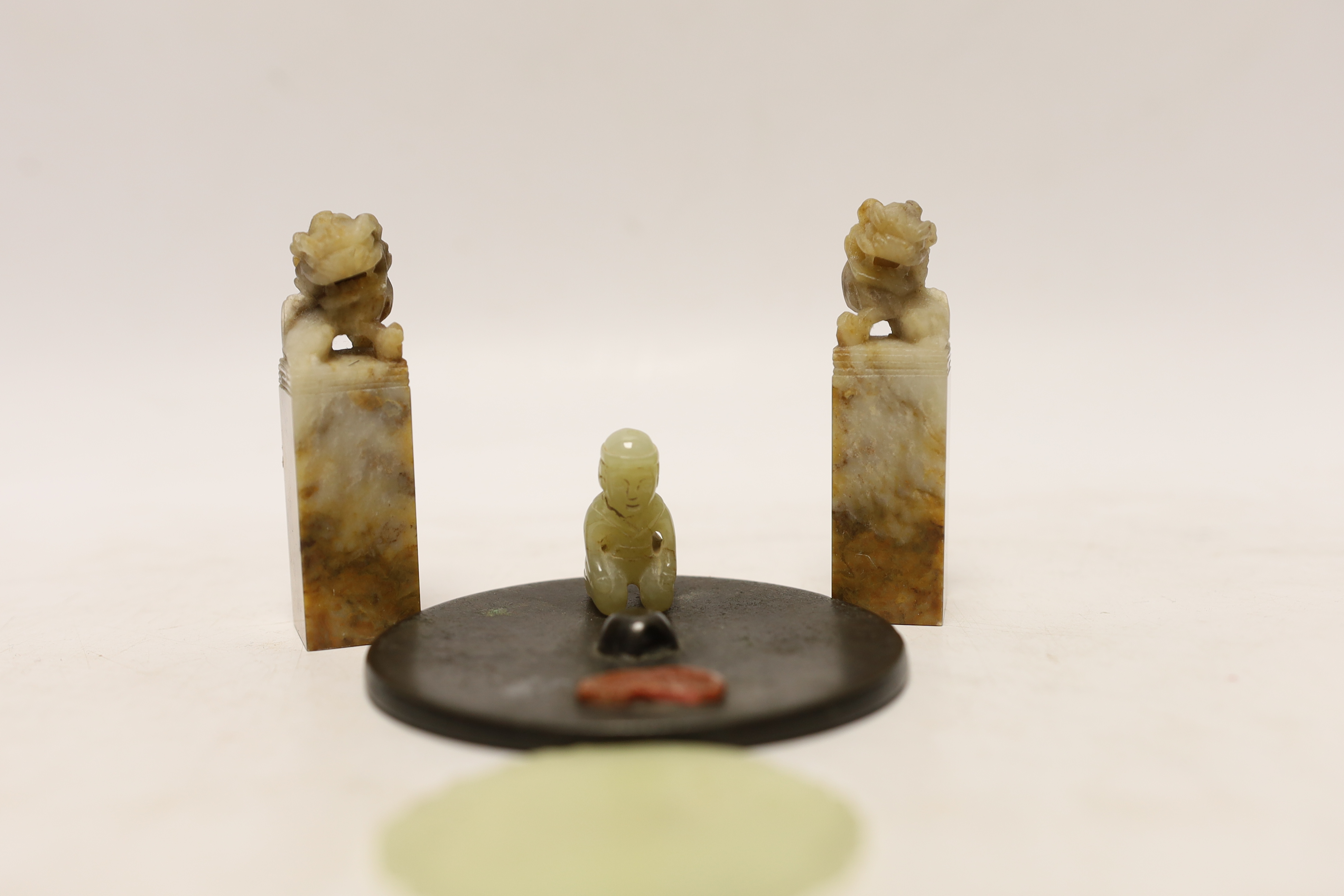 Two Chinese lion dog seals, a carved jade disc, a hard stone disc with partial wax seal and carved figure